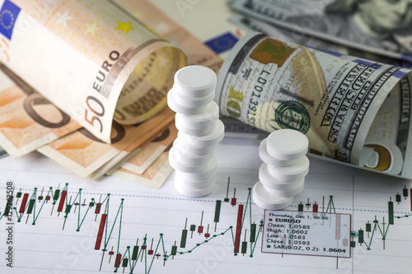 Obraz Currency exchange trading worries . Hundred us dollar bills and fifty euro banknotes in background. Currency us eur exchange chart under the bills.  Piles of sedative medical pills.