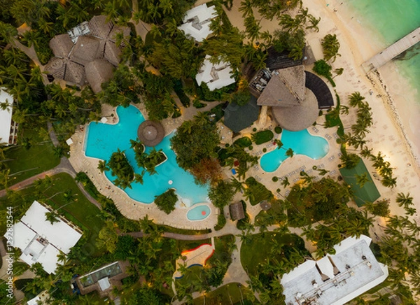 Obraz A beautiful beach resort with a pool and palm trees