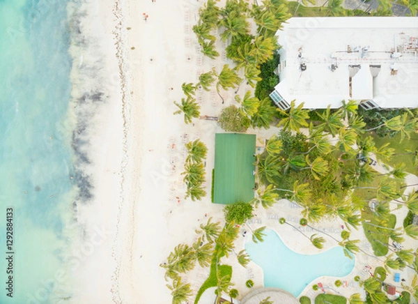 Fototapeta A beach with a green field and a pool