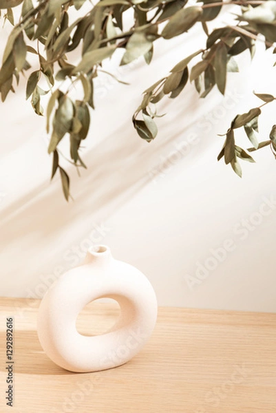Fototapeta Copy space warm lighting background. Blank wallpaper with leaf foreground and minimalist vase. Light and Shadow wallpaper. Space for text. Backdrop. Studio photography. Sunshine. Chic style. 
