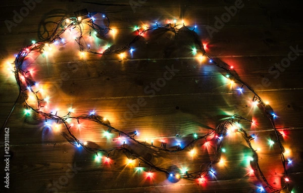 Fototapeta Christmas background with lights and free text space. Christmas lights border. Glowing colorful Christmas lights on black background. New Year. Christmas. Decor. Garland.