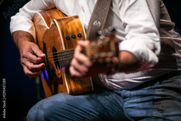 Fototapeta Man playing a guitar on stage (shallow DOF; color toned image)