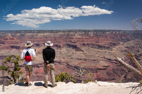 Fototapeta 2 tourists watching and admiring the view of Grand Canyon, Arizona, USA