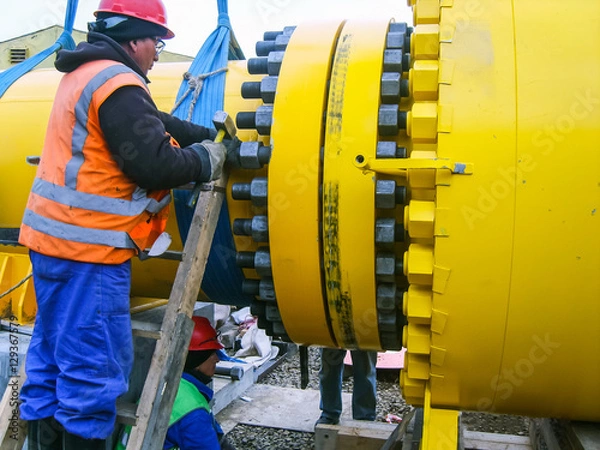 Fototapeta Work tighten the nuts on the flange