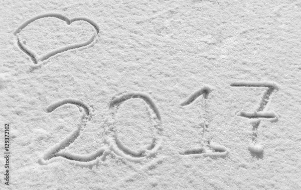 Fototapeta Merry Christmas and Happy New Year. Snowy background with hearts and the inscription 2017