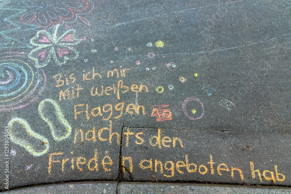 Fototapeta Words in German mean Until I will wave my white flag. Vibrant crayon drawings cover the asphalt, showcasing playful shapes, doodles, and creative expressions. A joyful scene of children's outdoor crea
