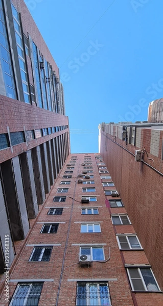 Fototapeta View of a multi-story brick building, viewed from bottom to top
