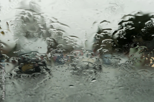Obraz Blurred view of a town road through a wet windscreen
