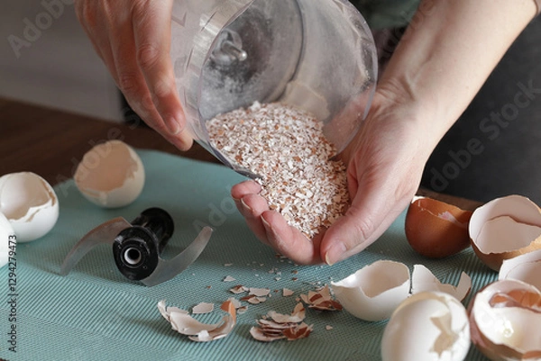 Fototapeta Preparing Eggshell Powder. Woman grinds eggshells with blender. Calcium supplement, cracked eggshell, natural compost ingredient, broken eggshell