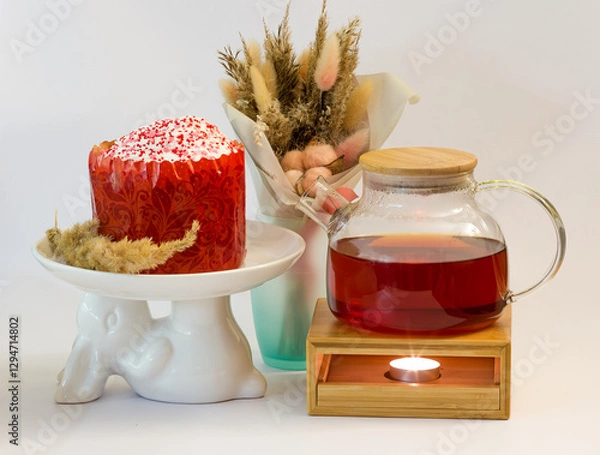 Obraz Easter cake on a plate in the shape of an Easter bunny with a teapot and a bouquet of dried flowers on a white background