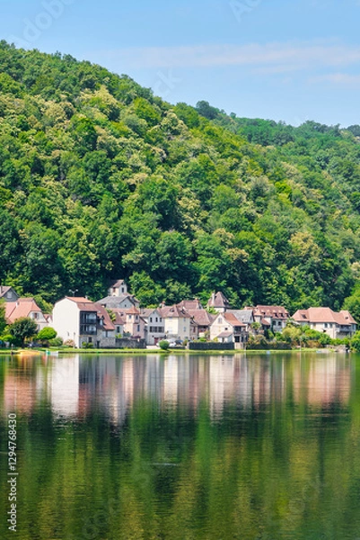 Fototapeta The village of Beaulieu-sur-Dordogne and the Dordogne river in Corrèze Nouvelle-Aquitaine in Southern France on a sunny day in summer