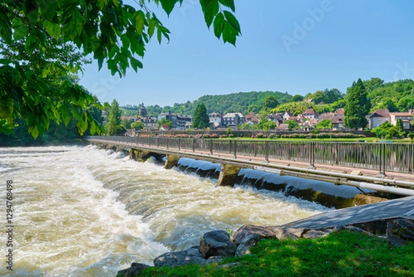 Fototapeta Weir and bridge over the Dordogne at Beaulieu-sur-Dordogne and the Dordogne river in Corrèze Nouvelle-Aquitaine in Southern France on a sunny day in summer  