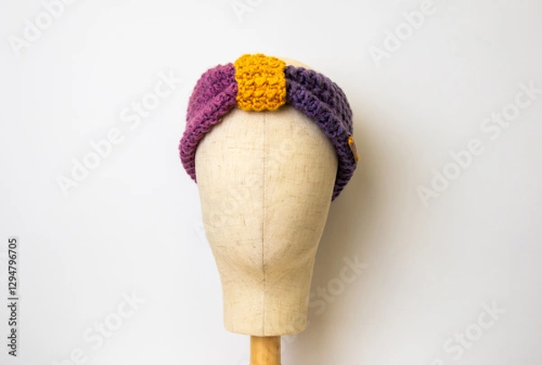 Fototapeta Crochet head band with a white background on a head display stand 