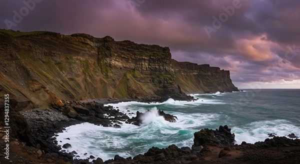 Fototapeta Ocean Waves Crashing Against Rocky Cliffs Under Dramatic Cloudy Sky