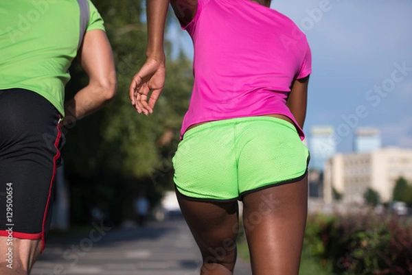 Obraz young smiling multiethnic couple jogging in the city