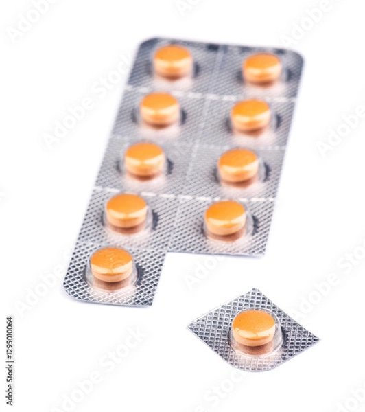 Fototapeta Orange tablets in blister pack arranged neatly on a white background for easy viewing