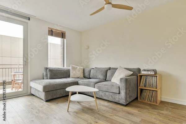Fototapeta A stylish and modern living room featuring a striped sofa, a round coffee table, and a warm wooden floor, creating a cozy atmosphere for relaxation and entertainment.
