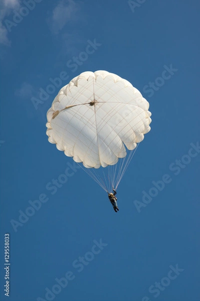 Obraz White round parachute on background blue sky.