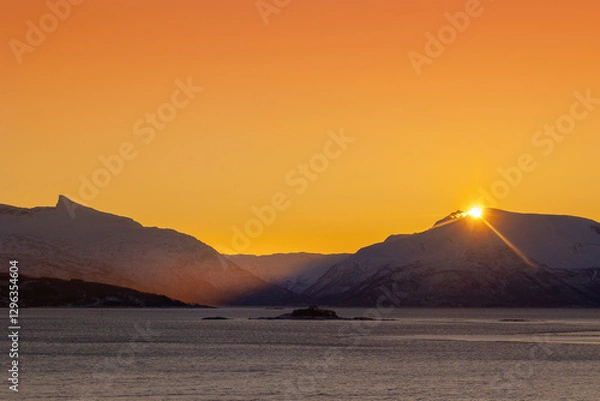 Obraz A beautiful sun shining over the snowy mountains and fjord during the first day of arctic winter. Arctic nature in Scandinavia during winter season.