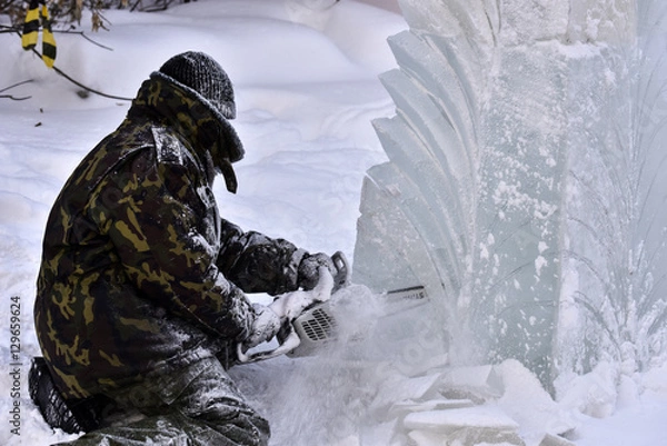 Obraz Worker using a chainsaw carving an ice sculpture