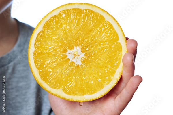 Fototapeta Cut juicy orange closeup in hand