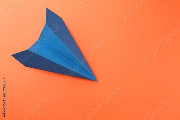 Fototapeta One handmade blue paper plane on orange background, top view. Space for text