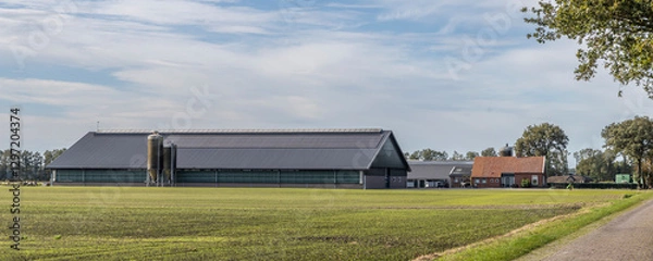 Fototapeta Old farmhouse with large modern stables with solar panels at the countryside of Drenthe The Netherlands