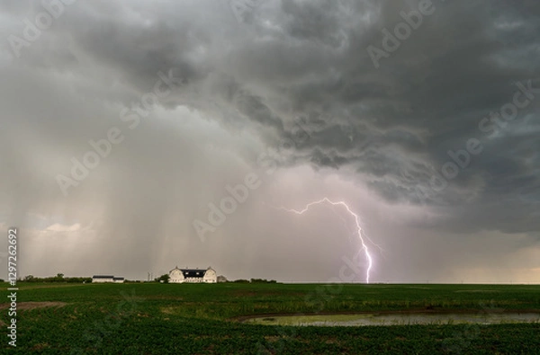 Fototapeta Lightning striking over farm during dramatic storm