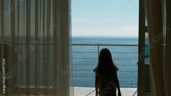 Fototapeta Mom and daughter go to the balcony with the sea view from the guest room