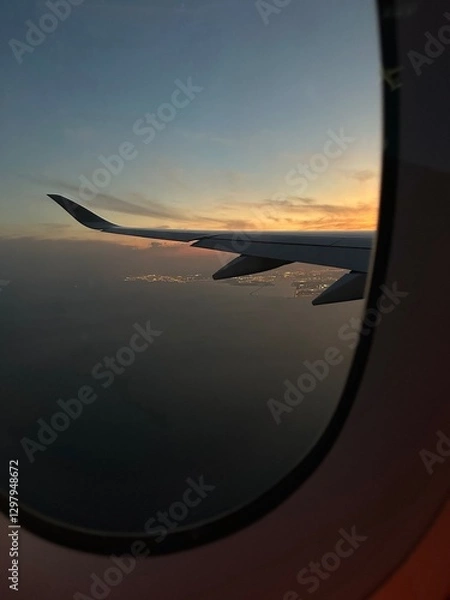 Fototapeta Airplane window view of sunset overlooking Doha, Qatar