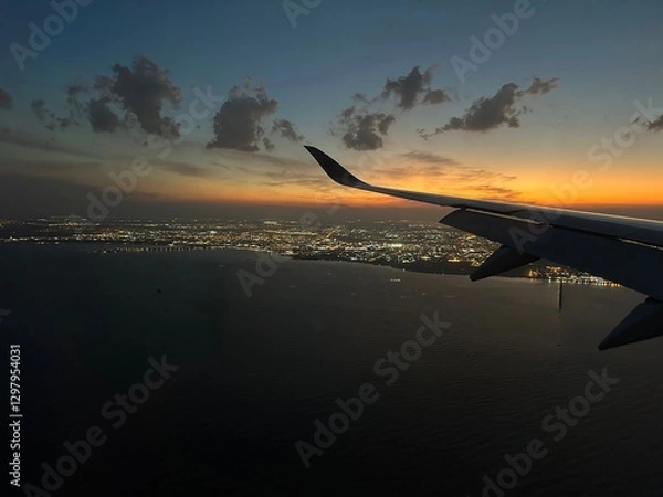 Fototapeta Airplane window view of sunset overlooking Doha, Qatar