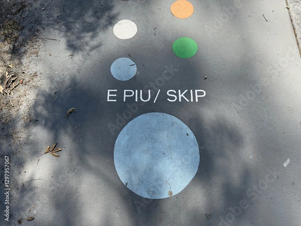 Fototapeta Markings on the tarmac of a playground have the words 'E Piu' and 'Skip'. Maori and English Language.New Zealand.