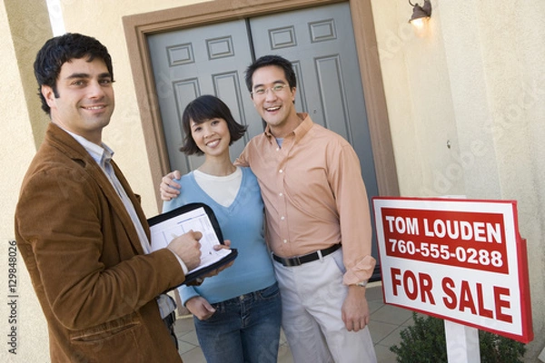 Fototapeta Portret szczęśliwa para z agentem nieruchomości stojący przed ich nowym domem