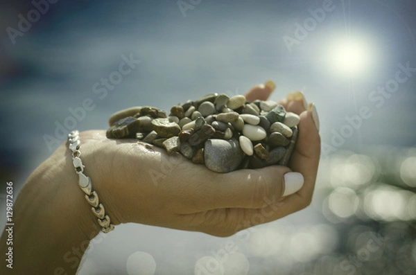 Obraz камни красиво выложенные на руке в лучах слонца