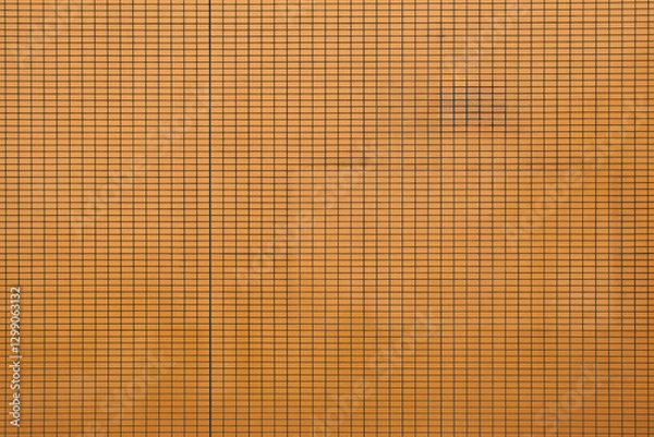 Fototapeta Textured wall with an orange grid pattern highlighting its structured design elements