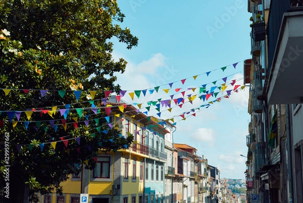 Fototapeta Festive bunting and lanterns decorate a narrow street for summer festival in June San Juan