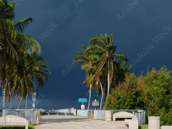 Fototapeta The entrance to the pedestrian walk on what used to be A1A's highway to Key West and now a fishing and excercise walking area under dark and menacing storm clouds due to Hurricane Milton
