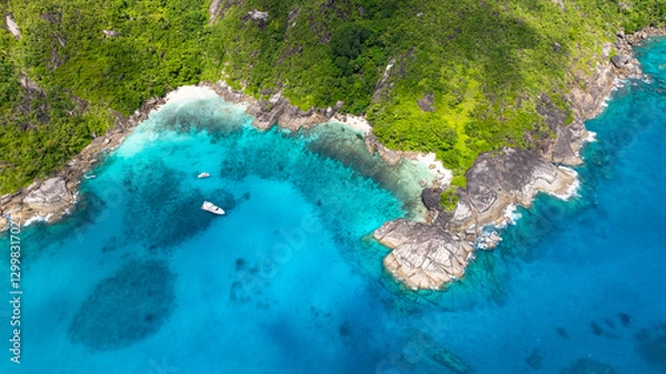 Fototapeta Aerial view of turquoise bay surrounded by rocky granite formations and lush greenery. Seychelles, Mahe.
