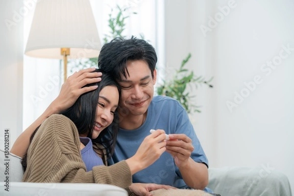 Fototapeta A happy couple sits together with a pug resting on their laps, showcasing an ultrasound image with smiles. The warm atmosphere captures their excitement about expecting a baby.