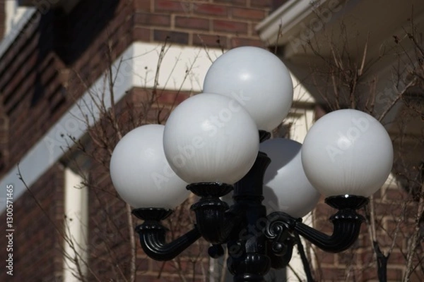 Fototapeta Vintage lamp post against a brick building