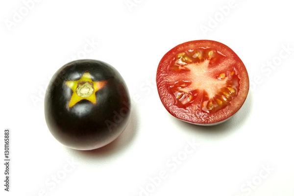 Fototapeta Two-color, red and black tomato whole and cut in half, on white background. Fresh and ripe. Top view