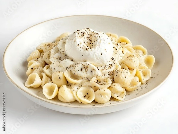 Fototapeta A plate of orecchiette pasta in a creamy truffle alfredo sauce, garnished with a whole burrata and freshly cracked black pepper, placed on a white background.