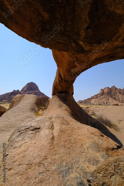 Obraz Inside the Spitzkoppe arch, revealing stunning granite landscapes of Damaraland with Spitzkoppe in the background.