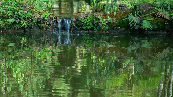 Fototapeta garden vegetation with flowers reflected distorted in still waters of lake water surface