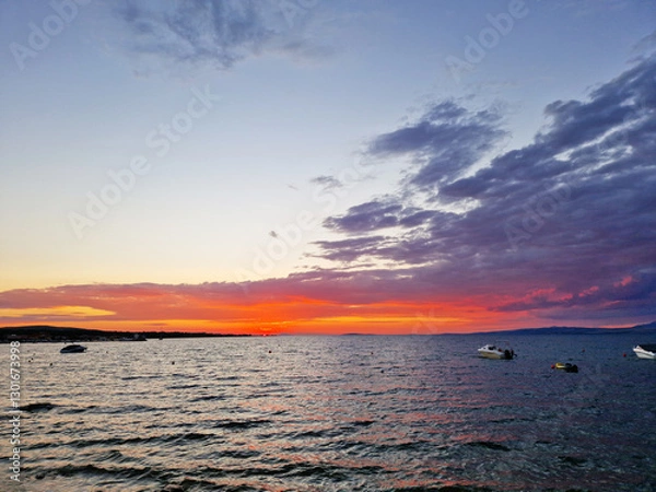 Obraz Vibrant sunset over the sea with boats and colorful clouds