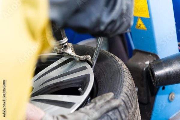 Obraz Tyre dealer fitting a tyre on a rim