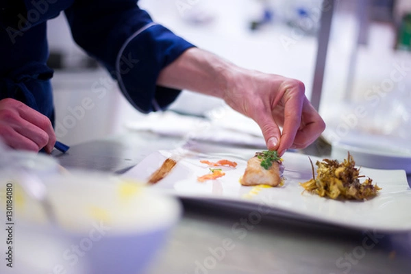 Obraz Chef preparing a cod filet with artichokes