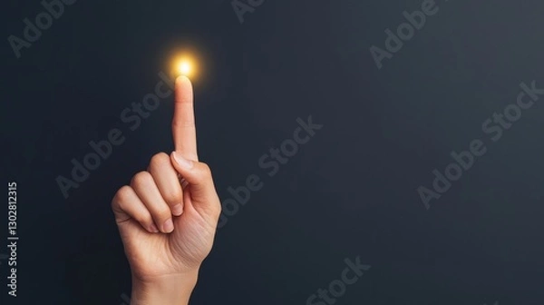 Fototapeta Close up of a hand with index finger pointing upwards emitting a bright glowing aura of energy and light symbolizing a creative concept spiritual enlightenment or a breakthrough idea