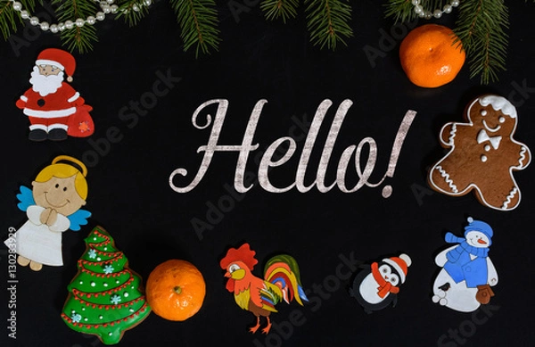 Fototapeta Xmas composition with text Hello on school blackboard and the Christmas decorations, toys (Santa Claus, Angel, a rooster, a snowman, a penguin) and tangerine