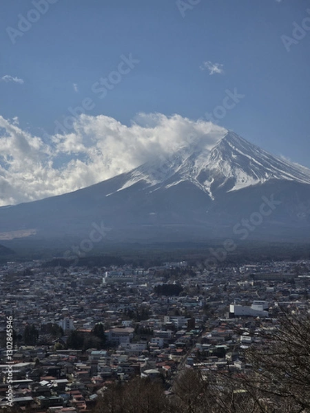 Obraz stunning view of Mount Fuji with clear blue sky and clouds, overlooking cityscape. majestic mountain stands tall, surrounded by urban development, creating beautiful contrast